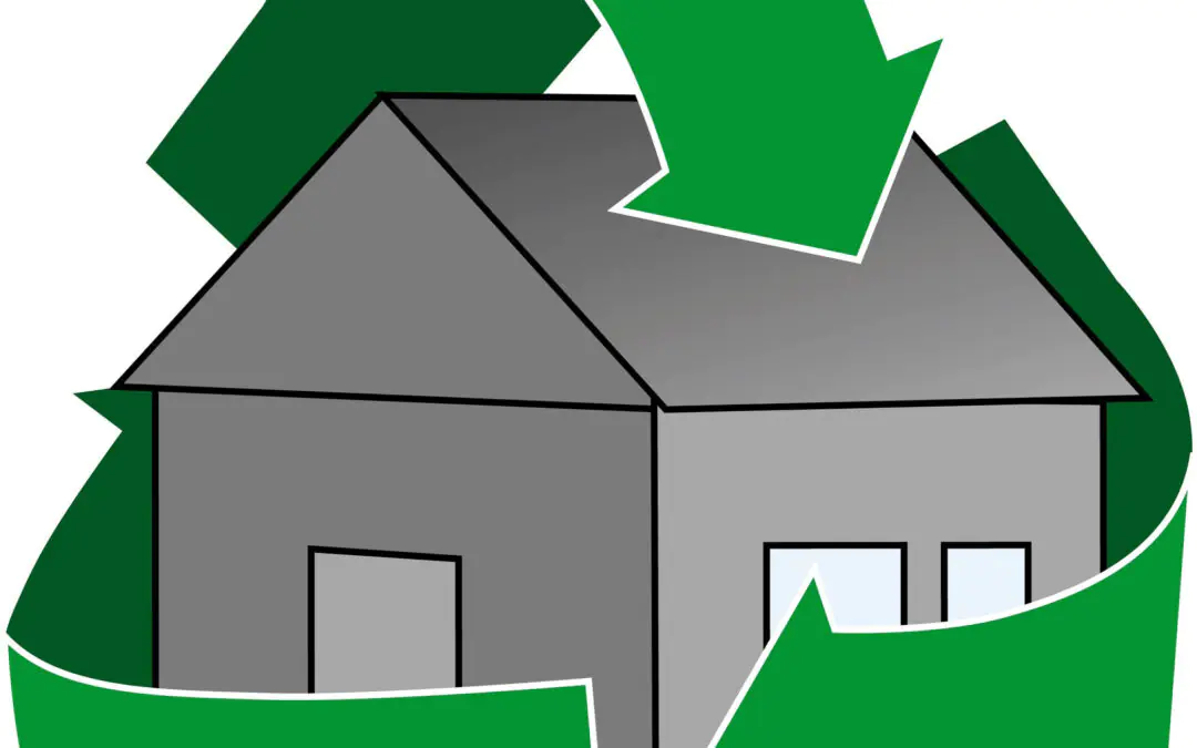 A gray house with an energy efficient roof is surrounded by a large green recycling symbol with three arrows forming a loop around it.