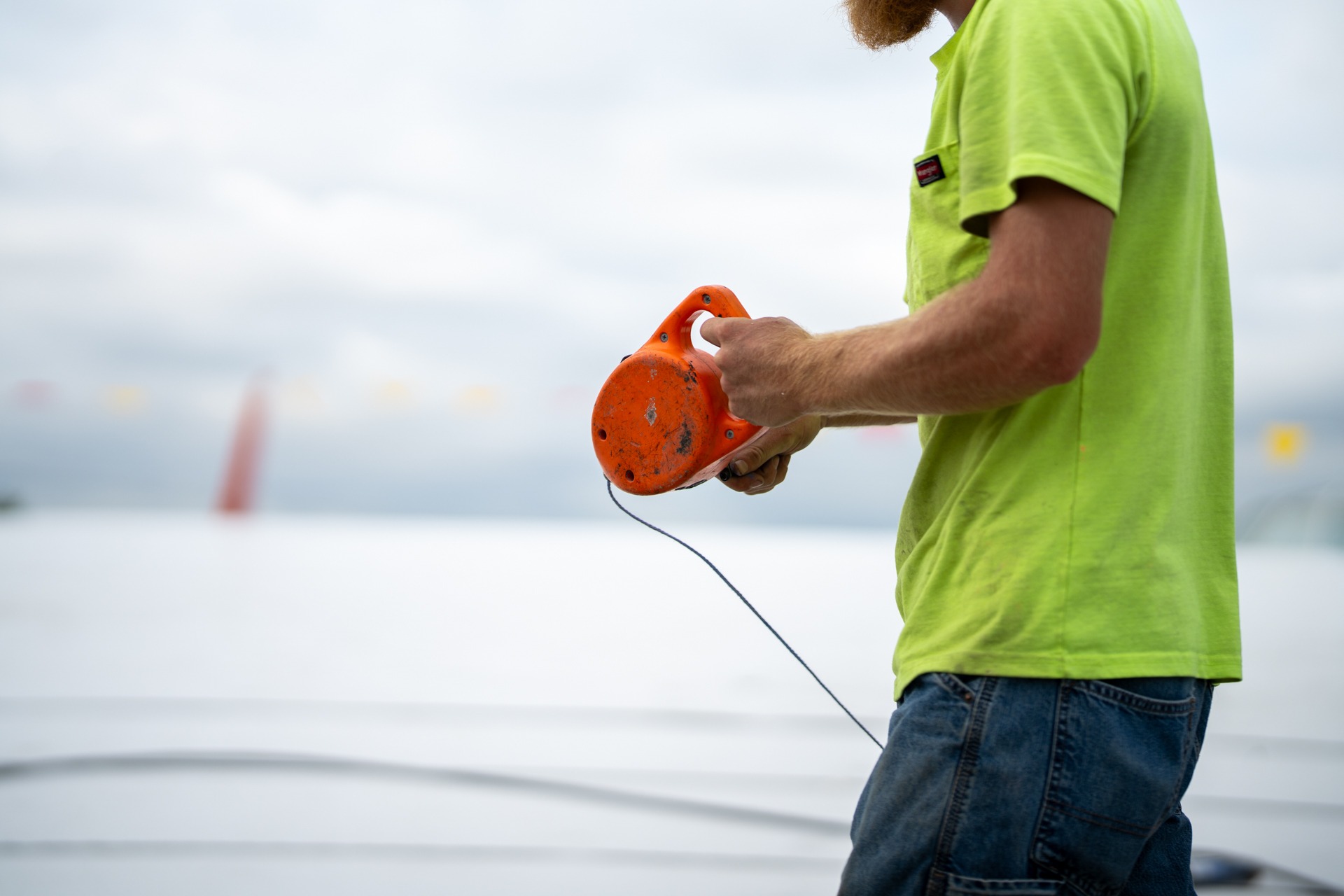 HCI equipment only — chalk line reel, flat roof surface, hand tool closeup